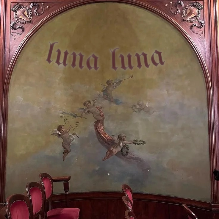 Side view of theater seats with a painted alcove behind them, the text "luna luna" above it on the wall